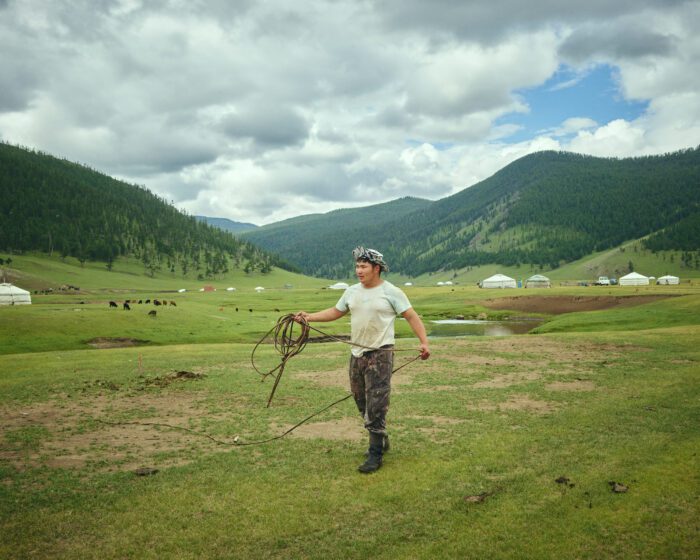 Homme marchant dans une vallée de montagne pendant un circuit en Mongolie