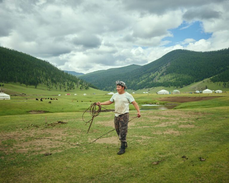 Homme marchant dans une vallée de montagne pendant un circuit en Mongolie